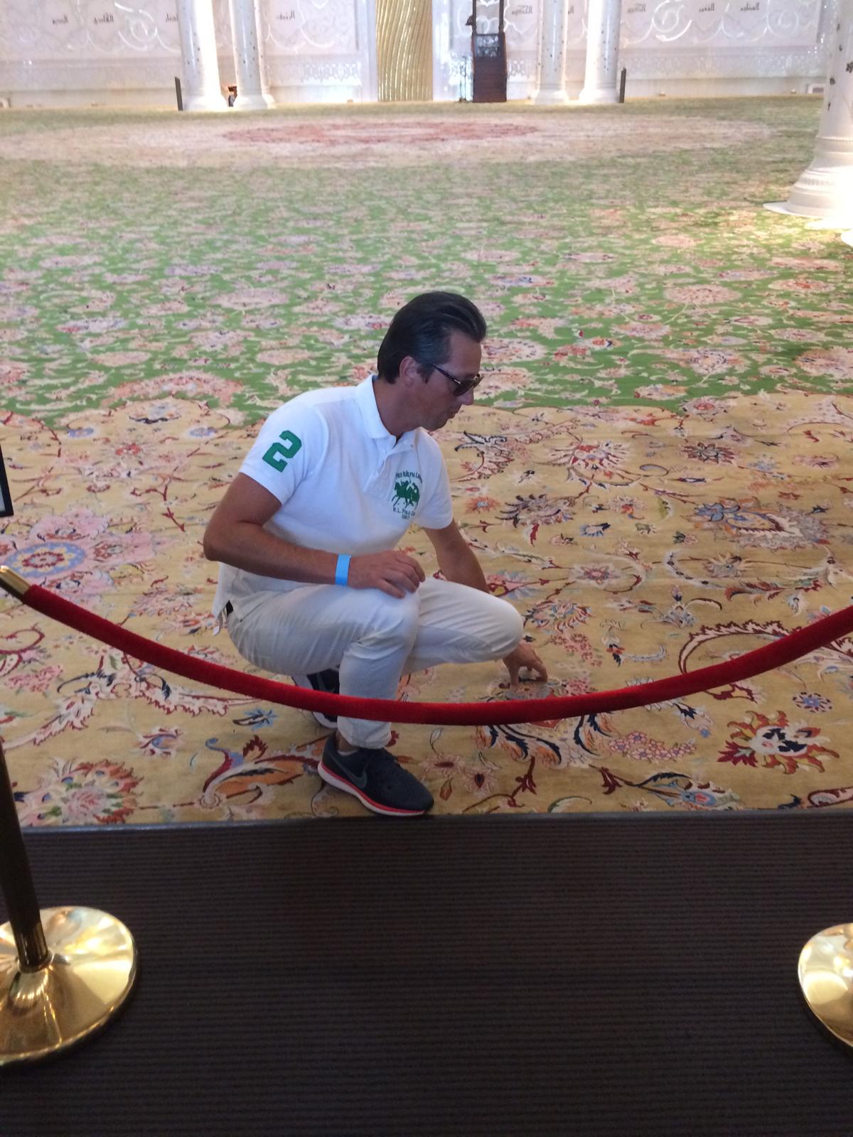 Personne examinant un tapis oriental.