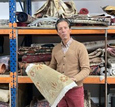Homme tenant un tapis oriental.