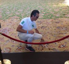 Un homme accroupi sur un tapis.