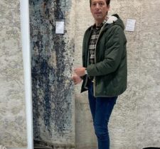Personne devant des tapis colorés.